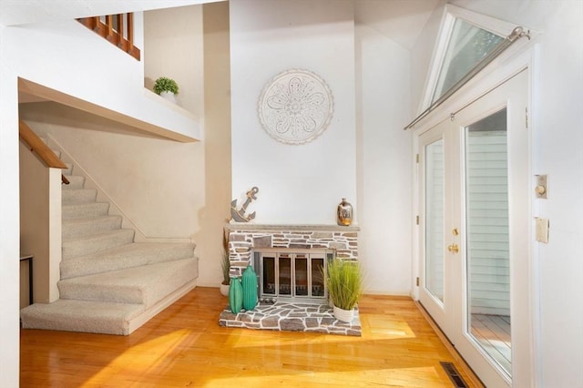 25 Church St Unit 2, Weymouth, MA 02189 - living room with wood finished floors, stairs, a towering ceiling, and a stone fireplace