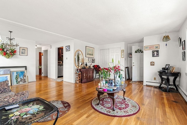 living room with wood finished floors, a chandelier, and baseboards