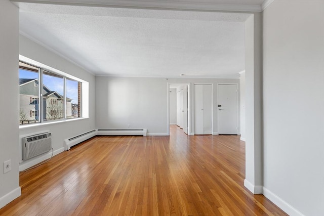 unfurnished living room with crown molding, a wall unit AC, a textured ceiling, a baseboard radiator, and light wood-type flooring