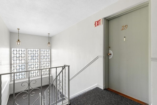 hallway with carpet floors and a textured ceiling