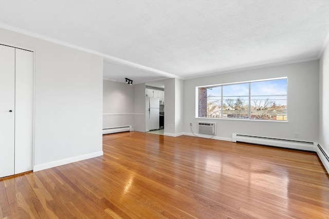 unfurnished living room featuring a baseboard radiator, ornamental molding, a wall mounted air conditioner, and light wood-type flooring