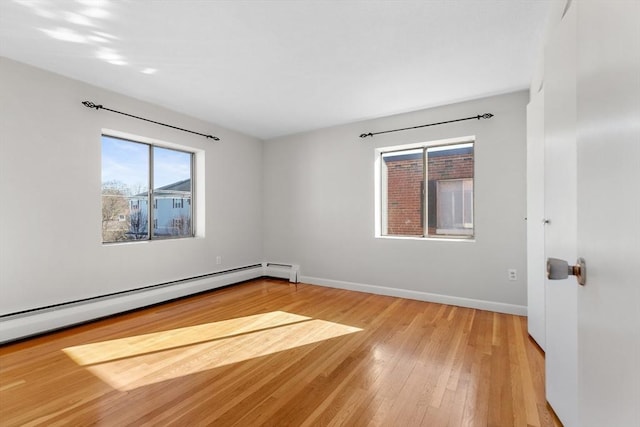 spare room with a baseboard radiator and light hardwood / wood-style flooring