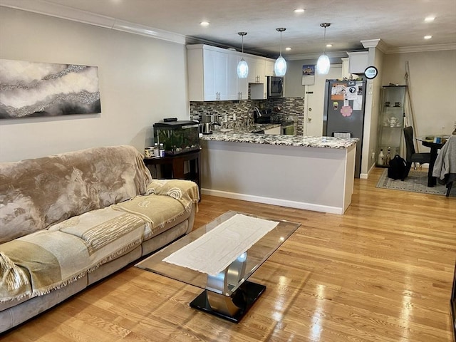 living room with light wood-type flooring and ornamental molding