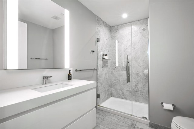 bathroom featuring vanity, toilet, and an enclosed shower