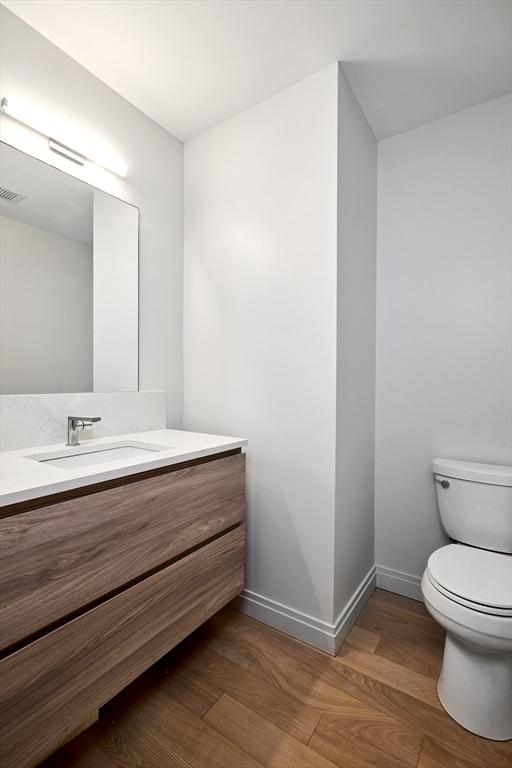 bathroom featuring hardwood / wood-style floors, vanity, and toilet