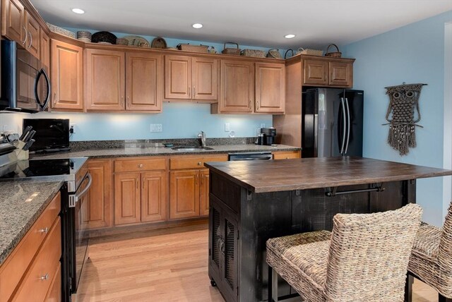74 E Main St Unit 3, Gloucester, MA 01930 - kitchen featuring black appliances, butcher block countertops, light wood-style flooring, recessed lighting, and a breakfast bar area