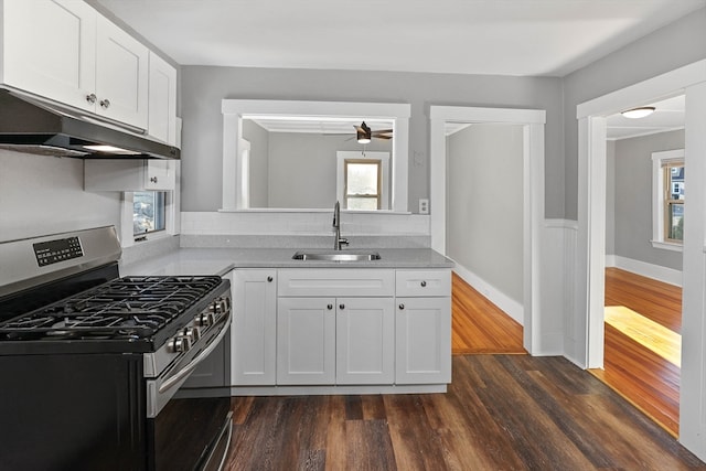 kitchen featuring stainless steel gas range oven, white cabinetry, sink, and a wealth of natural light