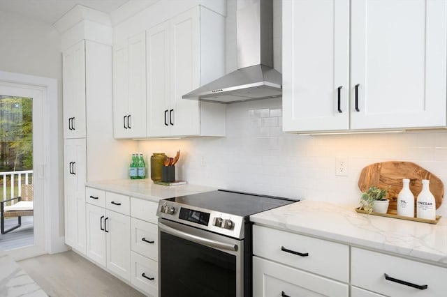 20 Howland Trl Unit 10, Hanson, MA 02341 - kitchen with stainless steel electric range, wall chimney exhaust hood, light stone countertops, tasteful backsplash, and white cabinets