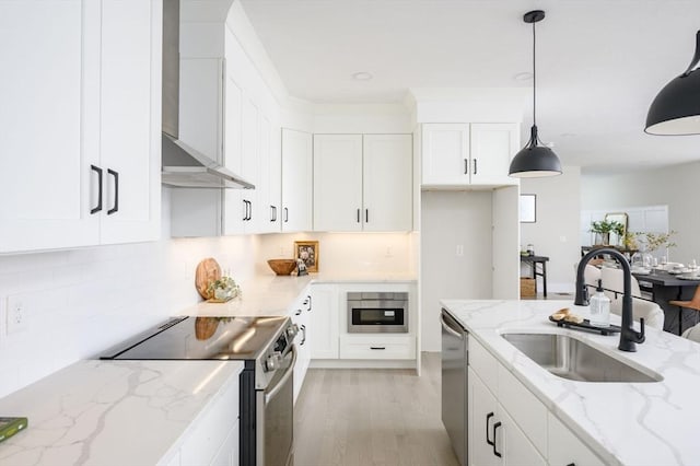 20 Howland Trl Unit 10, Hanson, MA 02341 - kitchen with stainless steel appliances, wall chimney exhaust hood, white cabinetry, and light wood-type flooring