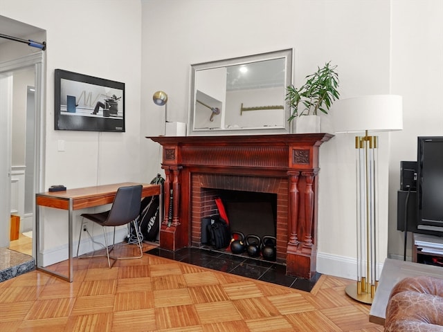 interior space featuring a brick fireplace and parquet floors