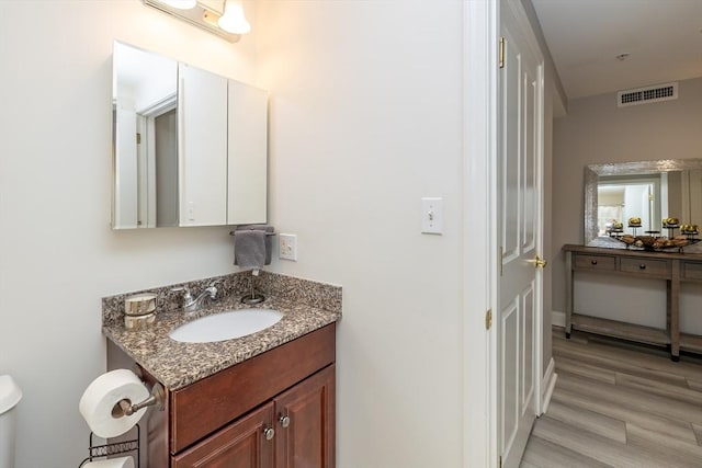 bathroom featuring vanity, toilet, and wood-type flooring