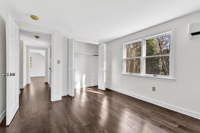 506 Woods Hole Rd, Falmouth, MA 02543 - unfurnished bedroom featuring dark wood finished floors, baseboards, a closet, and an AC wall unit