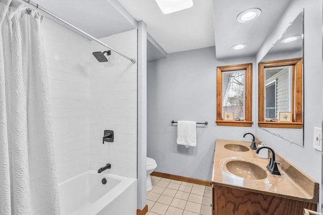 bathroom with toilet, baseboards, a sink, and tile patterned floors