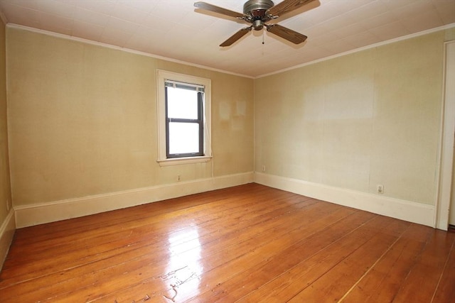 spare room with baseboards, ornamental molding, ceiling fan, and light wood-type flooring