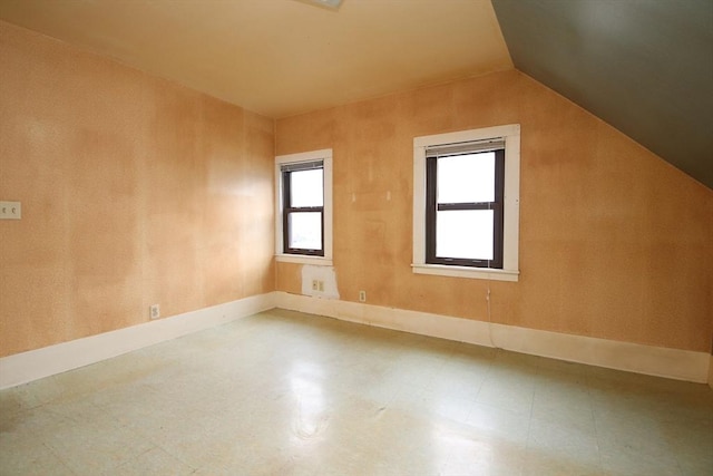 additional living space with baseboards and lofted ceiling