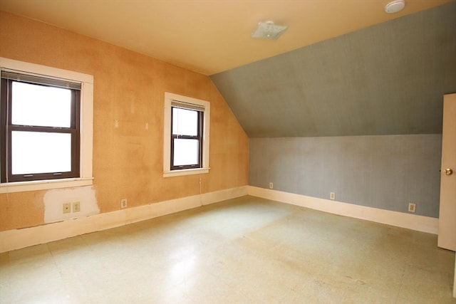 bonus room with tile patterned floors, vaulted ceiling, and baseboards