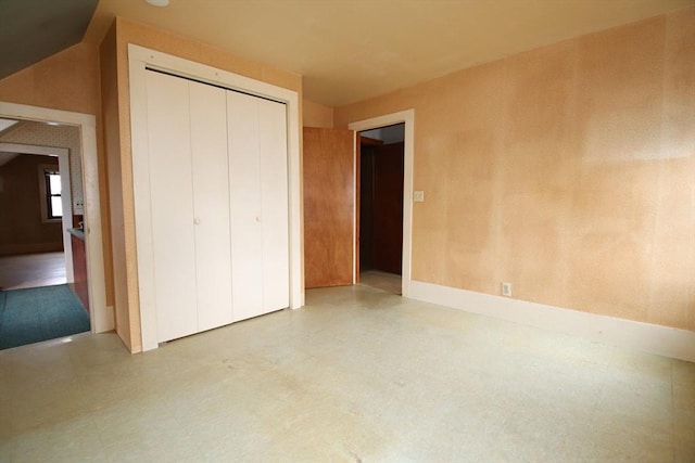 unfurnished bedroom featuring tile patterned floors, baseboards, and a closet