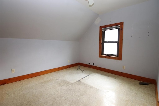 additional living space featuring baseboards, vaulted ceiling, and tile patterned floors
