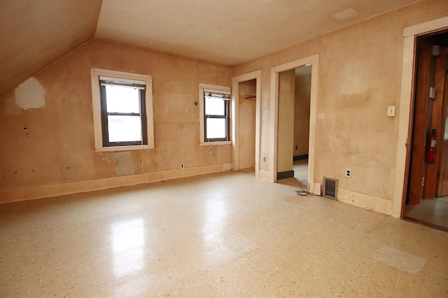 additional living space featuring visible vents and lofted ceiling