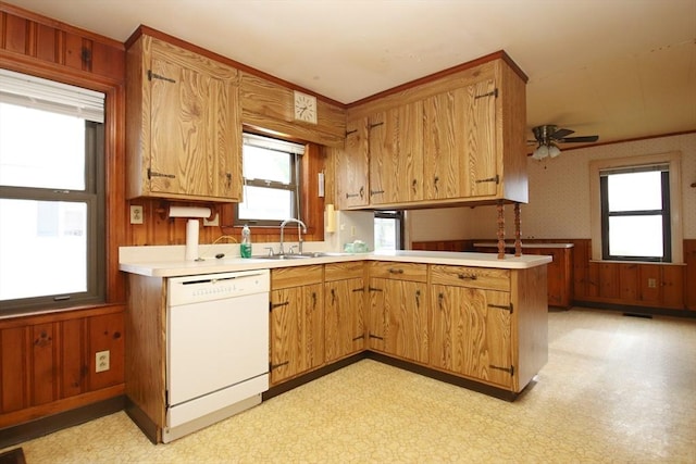 kitchen with light countertops, white dishwasher, a sink, and light floors