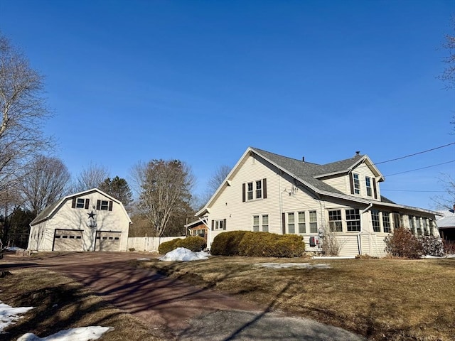 view of side of home featuring a gambrel roof, an outdoor structure, and a garage