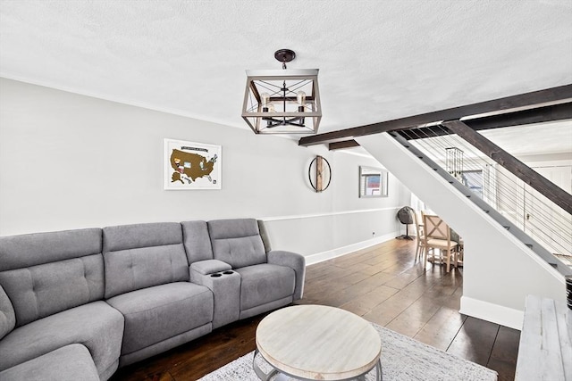 living room featuring a textured ceiling, stairs, baseboards, and hardwood / wood-style floors