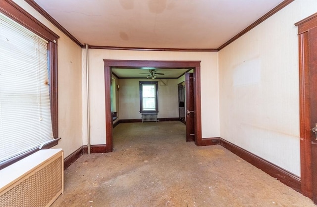 empty room featuring radiator, crown molding, baseboards, radiator heating unit, and unfinished concrete floors