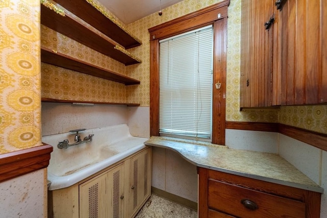 kitchen with wallpapered walls, light countertops, and open shelves