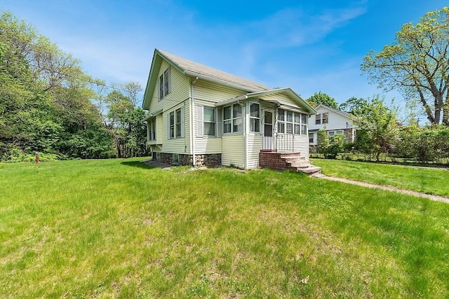 view of front of property featuring a sunroom and a front lawn
