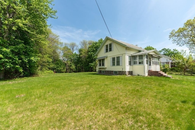 view of side of property featuring a yard and a sunroom
