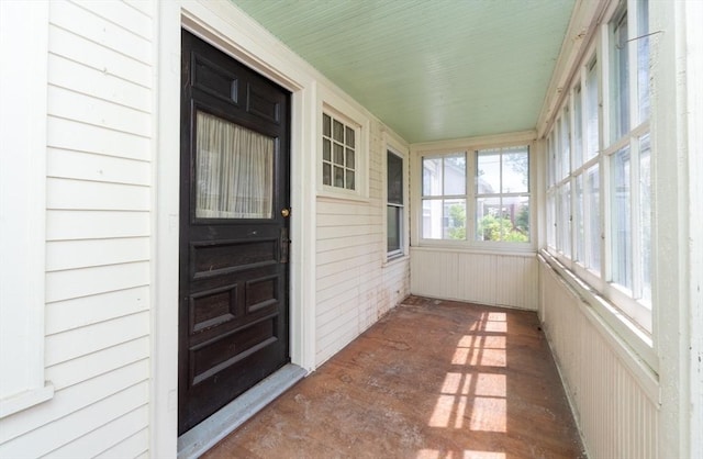 unfurnished sunroom featuring wooden walls