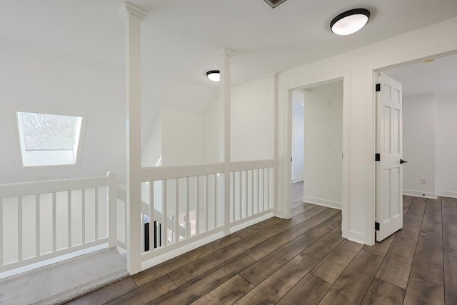 hall with dark hardwood / wood-style flooring and a skylight