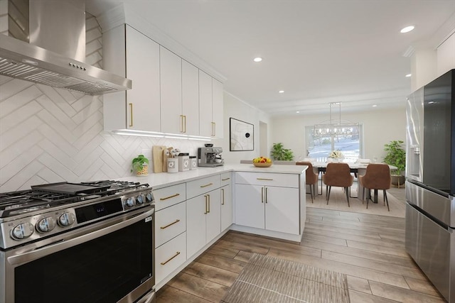 kitchen with backsplash, white cabinets, wall chimney exhaust hood, kitchen peninsula, and stainless steel appliances