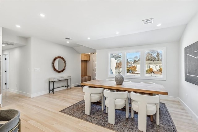 dining space featuring vaulted ceiling and light wood-type flooring