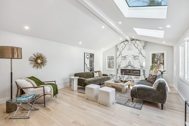 living room with a premium fireplace, lofted ceiling with skylight, and light hardwood / wood-style flooring