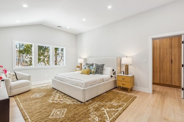 bedroom featuring light hardwood / wood-style floors and vaulted ceiling