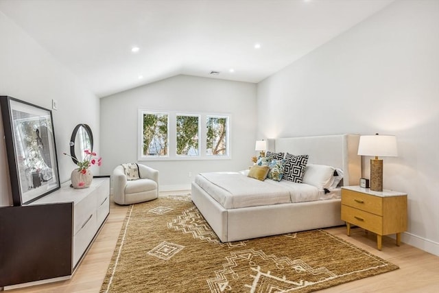 bedroom featuring lofted ceiling and light wood-type flooring