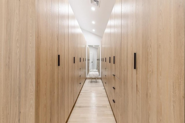 hall with lofted ceiling and wood walls