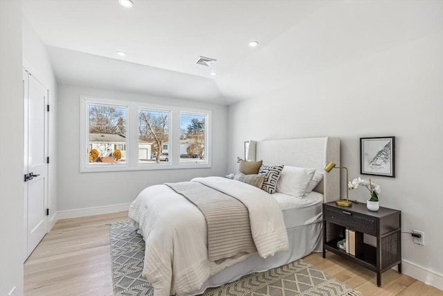 bedroom featuring lofted ceiling and light wood-type flooring