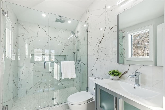 bathroom featuring toilet, tile walls, vanity, a shower with door, and decorative backsplash