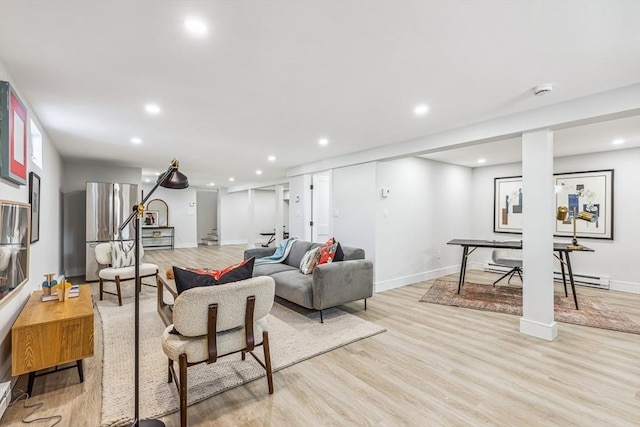 living room featuring a baseboard heating unit and light wood-type flooring