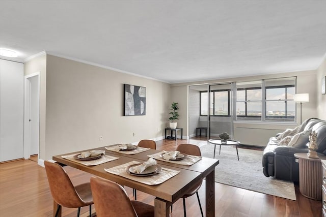 dining area featuring ornamental molding and hardwood / wood-style floors