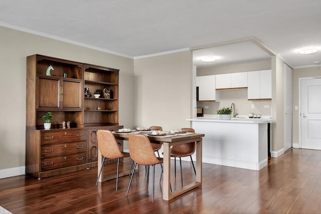 dining area with sink, dark hardwood / wood-style floors, and ornamental molding