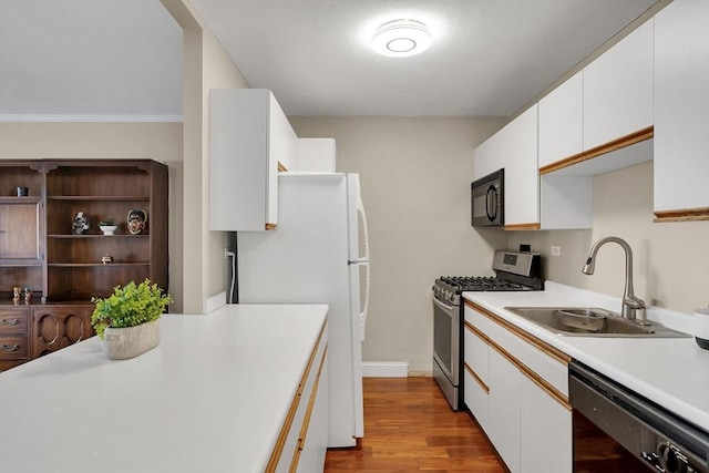 kitchen with white cabinetry, sink, light hardwood / wood-style floors, and black appliances