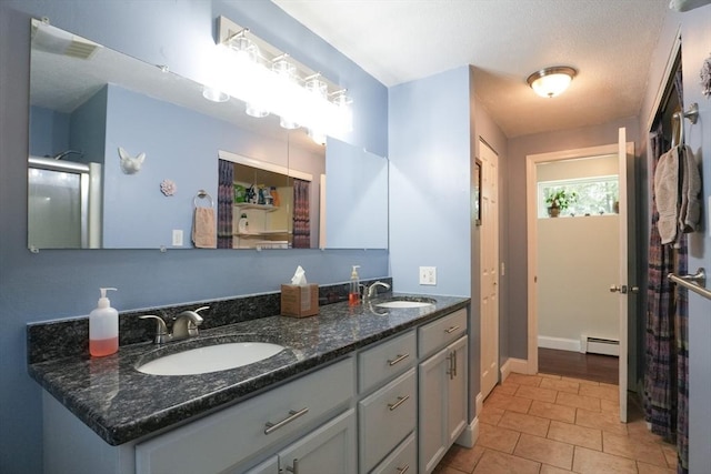 207 Belanger, Southampton, MA 01073 - bathroom with baseboard heating, double vanity, tile patterned floors, and a shower with shower door