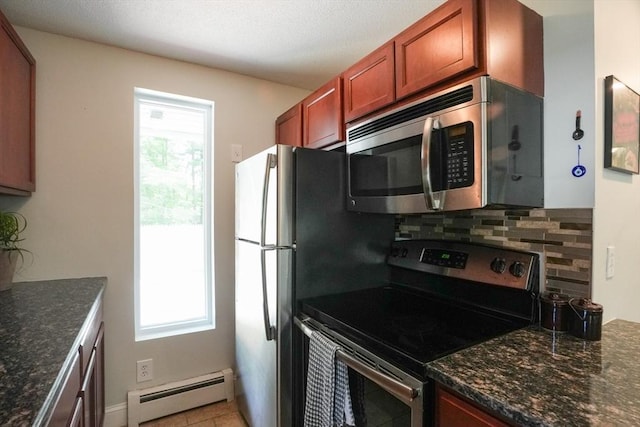 207 Belanger, Southampton, MA 01073 - kitchen featuring appliances with stainless steel finishes, a baseboard heating unit, tasteful backsplash, light tile patterned flooring, and dark stone countertops