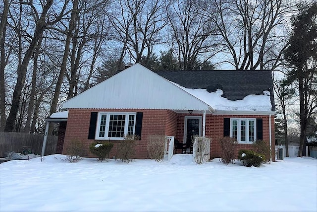 view of front of home featuring brick siding and fence