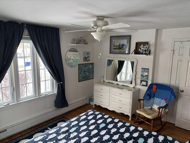 bedroom featuring dark wood-style floors, a baseboard radiator, and ceiling fan