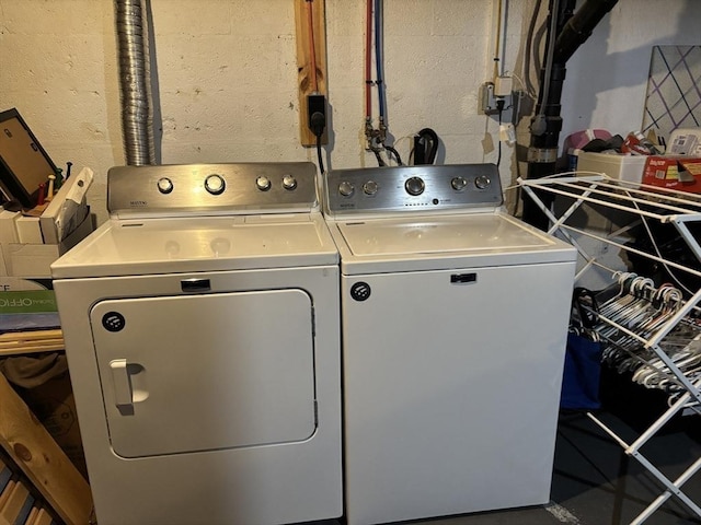 laundry area with laundry area, concrete block wall, and washer and dryer