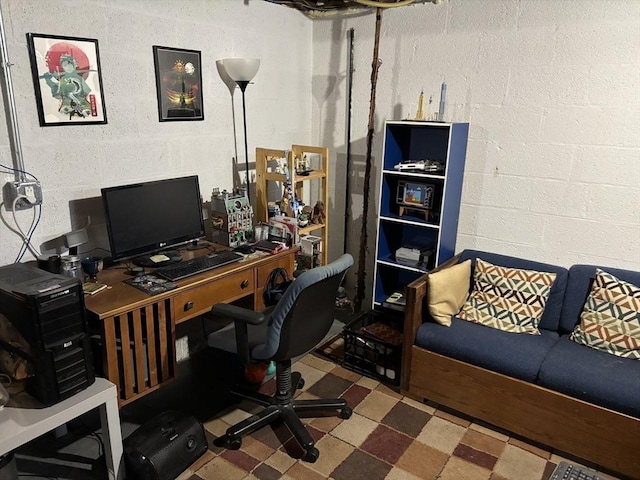 office with concrete block wall and tile patterned floors